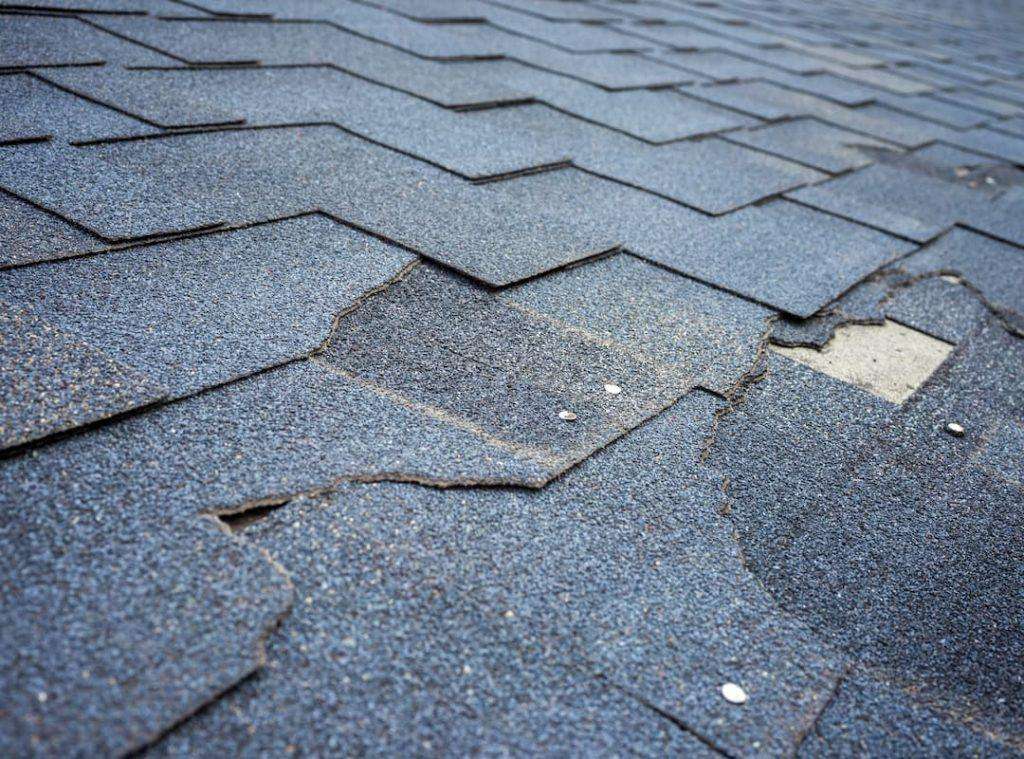 Close up view of bitumen shingles roof damage that needs repair